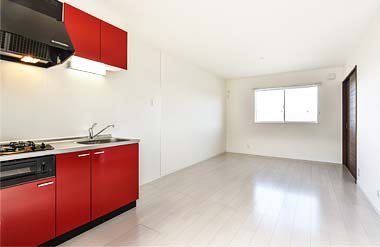 赤いキッチン　白系の床の室内
